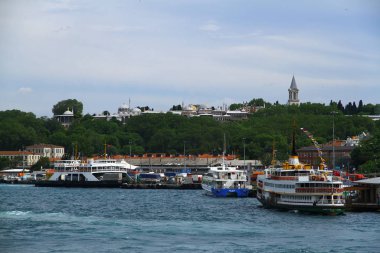 İskelede yolcu taşıyan limandaki feribotlara bakın.