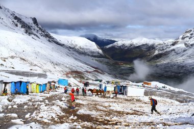 Vinicunca Gökkuşağı Dağları, Peru 'nun karlı tepelerinde atlar ve insanlar için barınaklar.