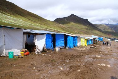 Vinicunca Gökkuşağı Dağları, Peru 'nun karlı tepelerinde atlar ve insanlar için barınaklar.