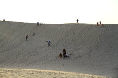 HUACACHINA, PERU - 11 Nisan 2019 İnsanlar Huacachina 'nın kum tepelerinde sörf yapıyor..
