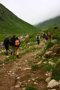 View on hikers trekking with backpacks walking in mountains, hiking, nature, tourist trip, travel concept