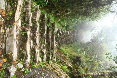 A view of the ancient Inca stairs in Inca Trail under heavy fog, Peru.