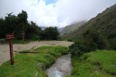 Bulutlu gökyüzünde yeşil dağları olan güzel dağ manzarasına bak..