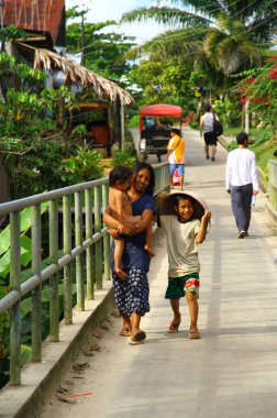Çocuklarıyla sokakta yürüyen mutlu bir kadın manzarası, Peru.