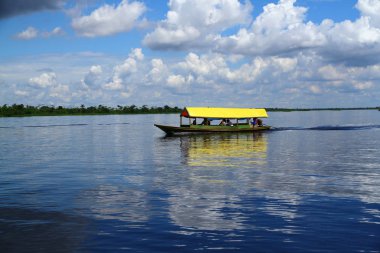 Iquitos Peru 'da Amazon Nehri' nin durgun sularında bir tekne yüzüyor.