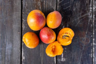 Eski siyah ahşap masadaki taze kayısıları kapat.