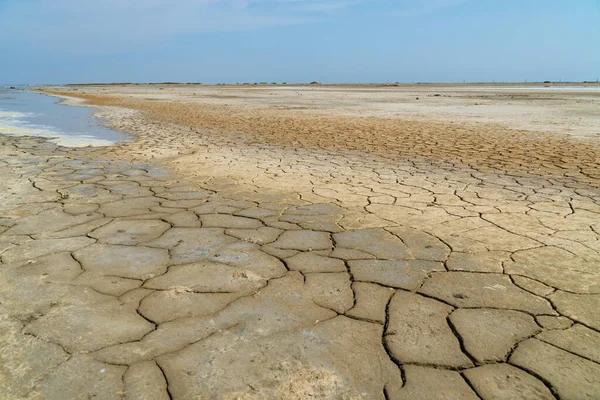 Den tørre jorden i et gammelt salthav under den blå himmelen – stockfoto