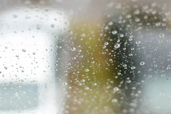 Krople wody na czyste jasne okno koncentruje się szczegółowo w mieście — Zdjęcie stockowe