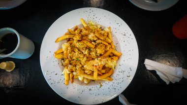 Peynirli bir tabak dolusu Kanada poutine 'i.