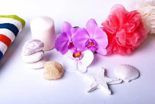 Комплект оздоровительных товаров, свеча, камни, губка красоты, морская звезда, полотенце, цветы, натуральная губка — стоковое фото