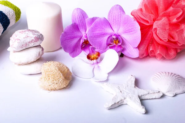 A set up of wellness items, a candle, stones, a beauty sponge, a sea star, towel, flowers, a natural sponge — Stock Photo, Image