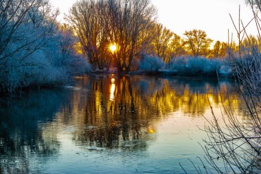 Renkli gündoğumunda kış sabahının erken saatlerinde bir nehir.