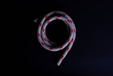 Siyah arka planda kırmızı beyaz bir yelken ipi.