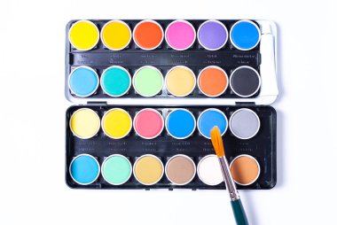 Renkli bir resim seti ve beyaz arkaplanda bir boya fırçası.