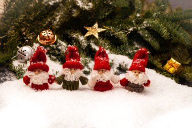 Dört noel cücesinden oluşan bir grup ormanın önündeki karda duruyor.