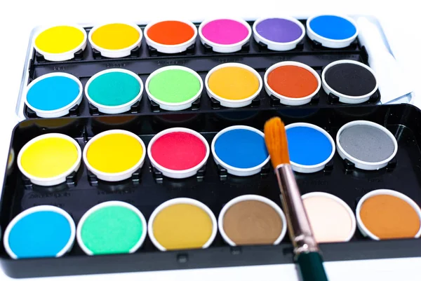 En färgglad målning set och en pensel på vit bakgrund — Stockfoto