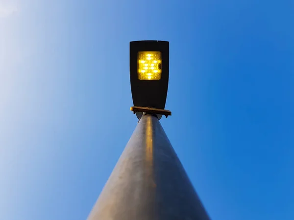 A modern LED street light in the city during the day