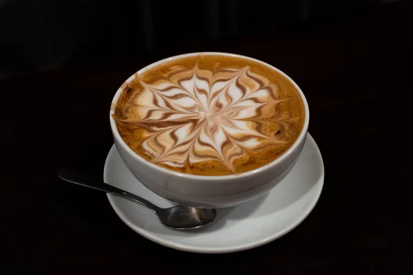 一杯加了花的卡布奇诺咖啡 背景是黑色的 拿铁咖啡店的概念 — 图库照片
