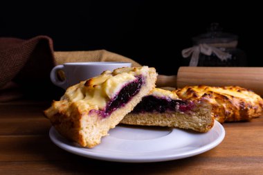 Lezzetli cheesecake kurabiyeleri yabanmersinli ve ahşap bir tahtanın üzerinde fotokopi alanı olan bir fincan kahve.