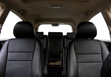 Arabanın içi gösterge panelinden fotoğraflanmış. Fotoğraf ön koltukları, arka koltukları ve bej tavanı gösteriyor..