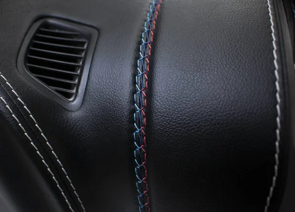 黑色皮革汽车面板上的彩色接缝 — 图库照片