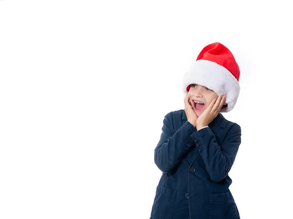 Młody chłopiec w kapeluszu Mikołaja i patrząc zaskoczony — Zdjęcie stockowe