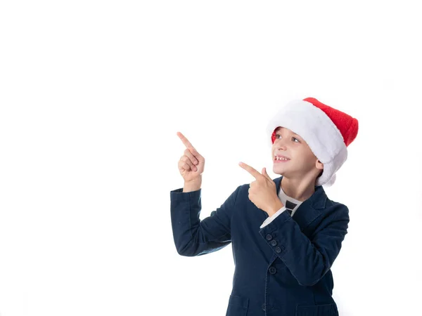 Młody chłopiec z kapeluszem Mikołaja wskazującym na coś — Zdjęcie stockowe