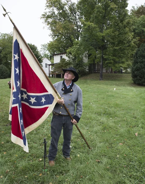 Hombre con traje histórico sosteniendo bandera confederada — Foto de Stock