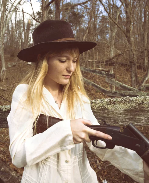 Jeune femme blonde vérifiant un fusil de chasse — Photo