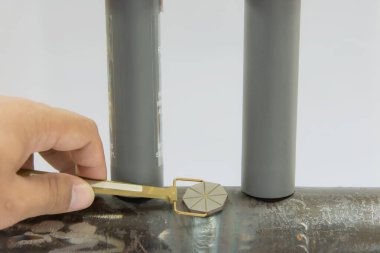 İnsan eli, Pie Field göstergesini tutuyor ve iki daimi mıknatıs arasındaki kaynağa yerleştiriyor. Turta göstergesi manyetik alanın yönünü belirlemek için kullanılan bir aygıttır.