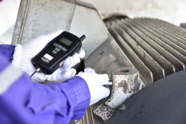 Müfettiş, yatakları ve genel motor titreşimlerini kontrol etmek için el bilgisayarı kullanıyor. Teftiş alanına seçici odaklanma.