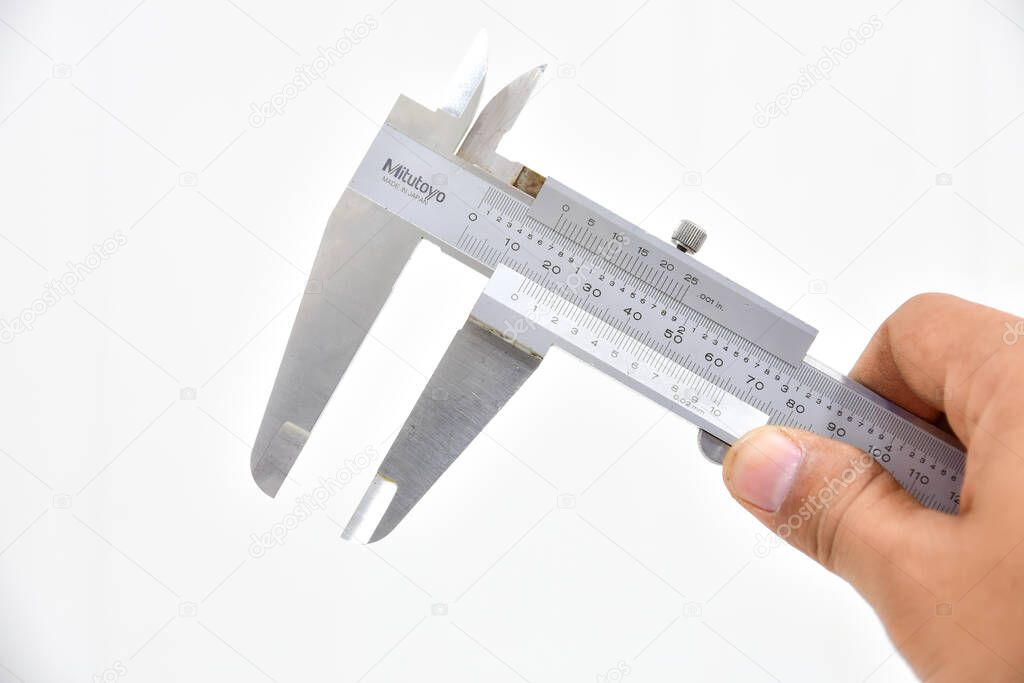 Vernier caliper and mechanic's hand isolated white on background. A type of sliding calipers for measuring the external or internal dimensions of objects, using the vernier scale for improved precision