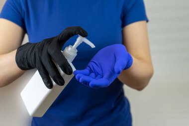 Cerrahi eldivendeki eller antiseptik kullanıyor. Bir kavanozda şeker kutusu var..