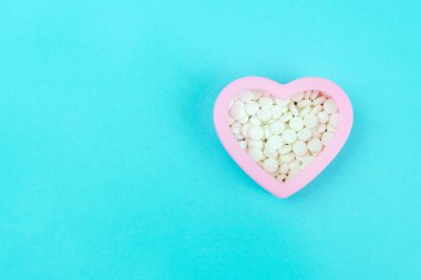 İçi beyaz haplarla dolu. Hap kutusu kalp şeklinde..