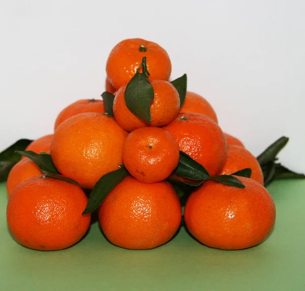 Pomarańczowe Mandarynki Liśćmi Ułożone Kształcie Góry Dużo Mandarynek Liśćmi Bardzo — Zdjęcie stockowe