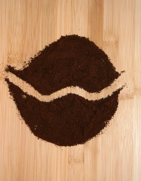 Ground coffee beans on a light background. Ground coffee is laid out in the form of a coffee bean.  Ground coffee with a painted strip.