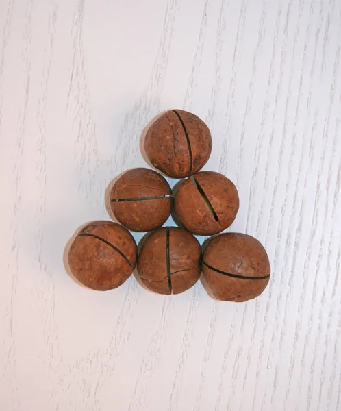Ολόκληρα Καρύδια Macadamia Ανοιχτό Ξύλινο Φόντο Αρκετοί Ξηροί Καρποί Μακαντέμια — Φωτογραφία Αρχείου