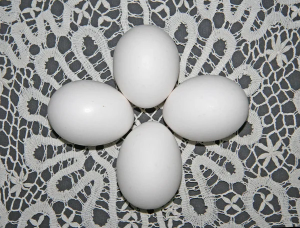 四个简单的白色蛋躺在莱西的背景上 白色花边餐巾上有纯白的鸡蛋 一群白蛋 蛋的组成 — 图库照片