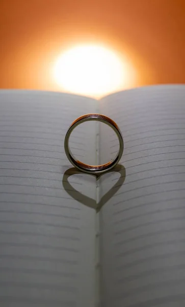 Prsten tvoří srdce na knize podsvícením — Stock fotografie
