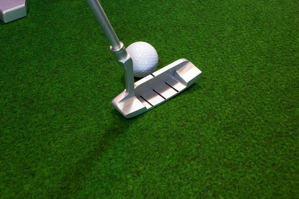 Putter, bola de golfe e destino para a vida de escritório relaxado — Fotografia de Stock