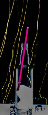 Ön planda cam şişe. Hafif boyayla çerçevelenmiş.