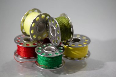 Farklı iplik renklerine sahip bir dikiş makinesinin iplik bobinleri