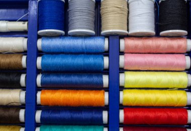 Farklı iplik renklerine sahip bir dikiş makinesinin iplik bobinleri