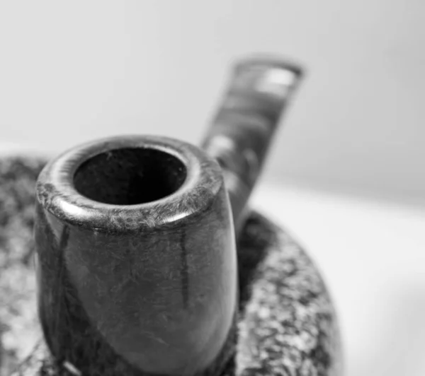 Macro picture red-brown pipe on an ashtray black and white — Stockfoto