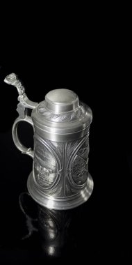 Kabartmalı teneke bardağın tozlu kapağı.