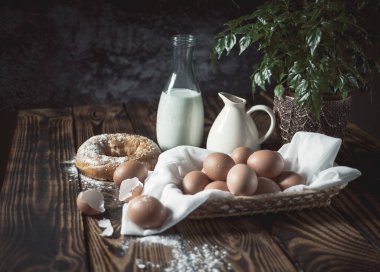 Yumurta, süt, peynir ve ekmek ahşap masada.