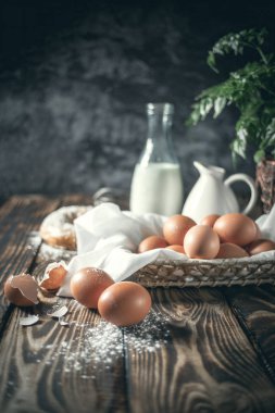 Kapalı alanda tavuk yumurtaları sepette, köy tahtalarında ve karanlık arka planda