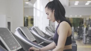 Spor salonunda koşu bandında koşan fitness kızı. Spor kulübünde kardiyo eğitimi