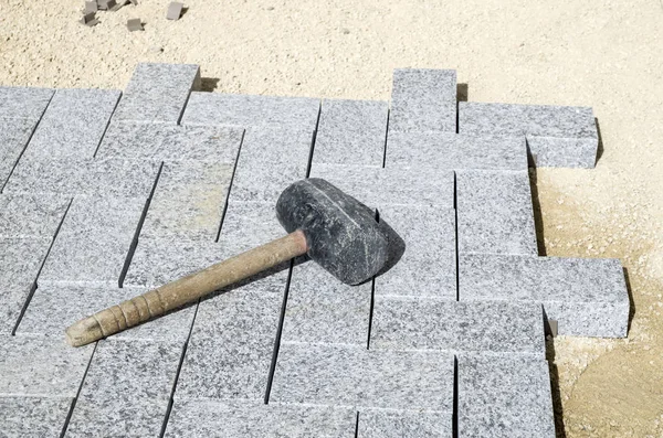 Mazo de goma en un nuevo pavimento de granito — Foto de Stock