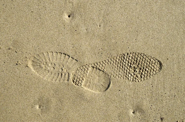 Mittemot avtryck av skor i våt sand — Stockfoto